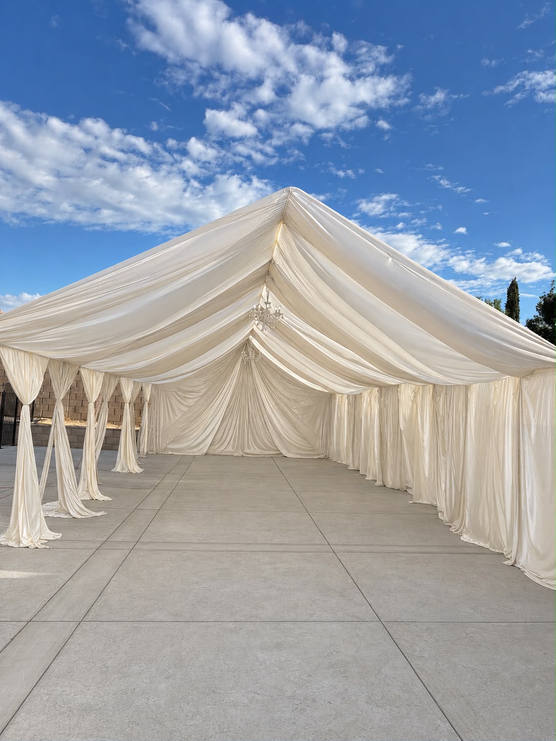 Real Loren's Party Rentals Soft ivory draping in an open event tent. Style inspiration, not a size-specific product photograph.