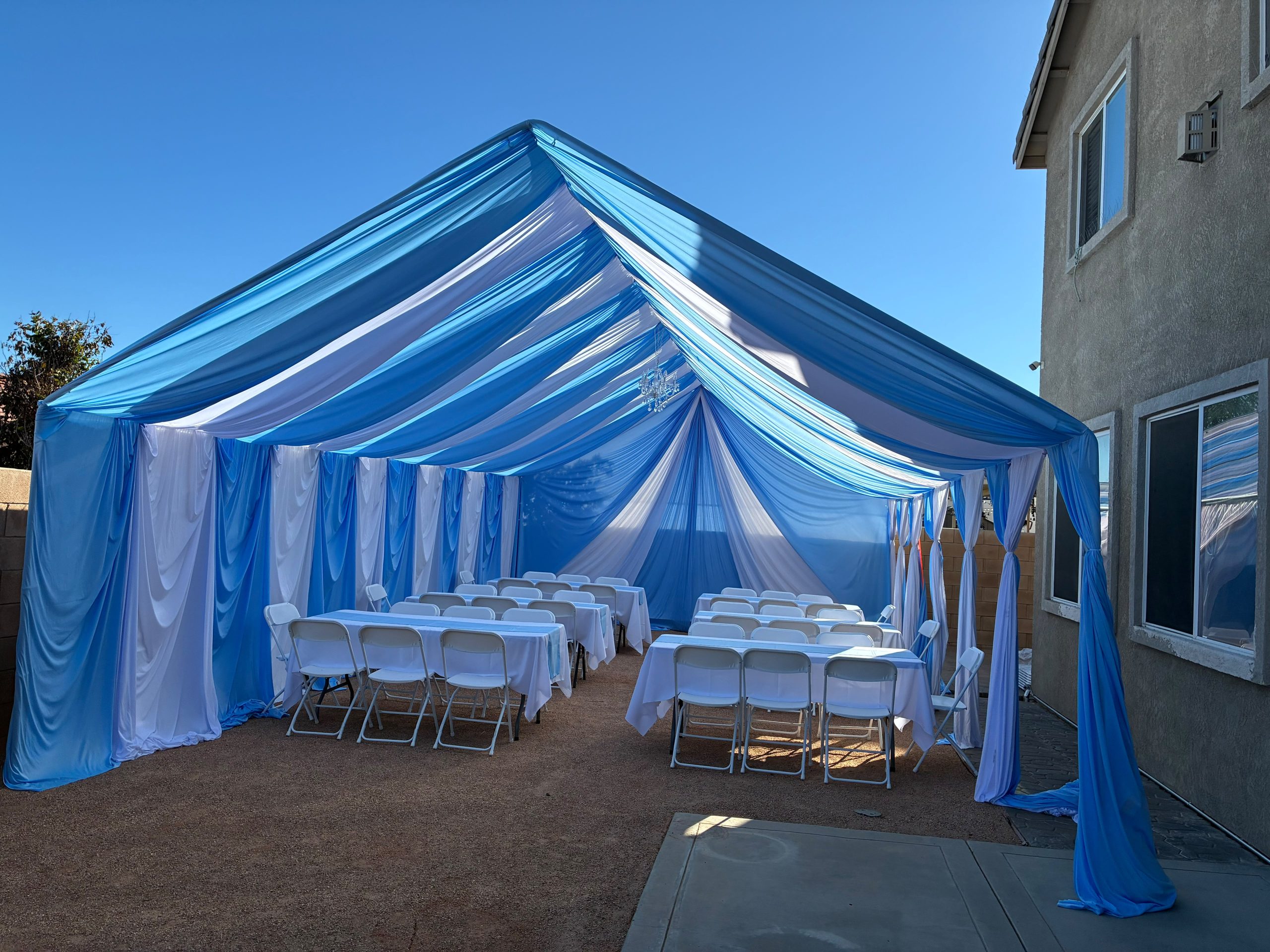 Real Loren's Party Rentals Blue and white draped tent arranged for a celebration. Style inspiration, not a size-specific product photograph.
