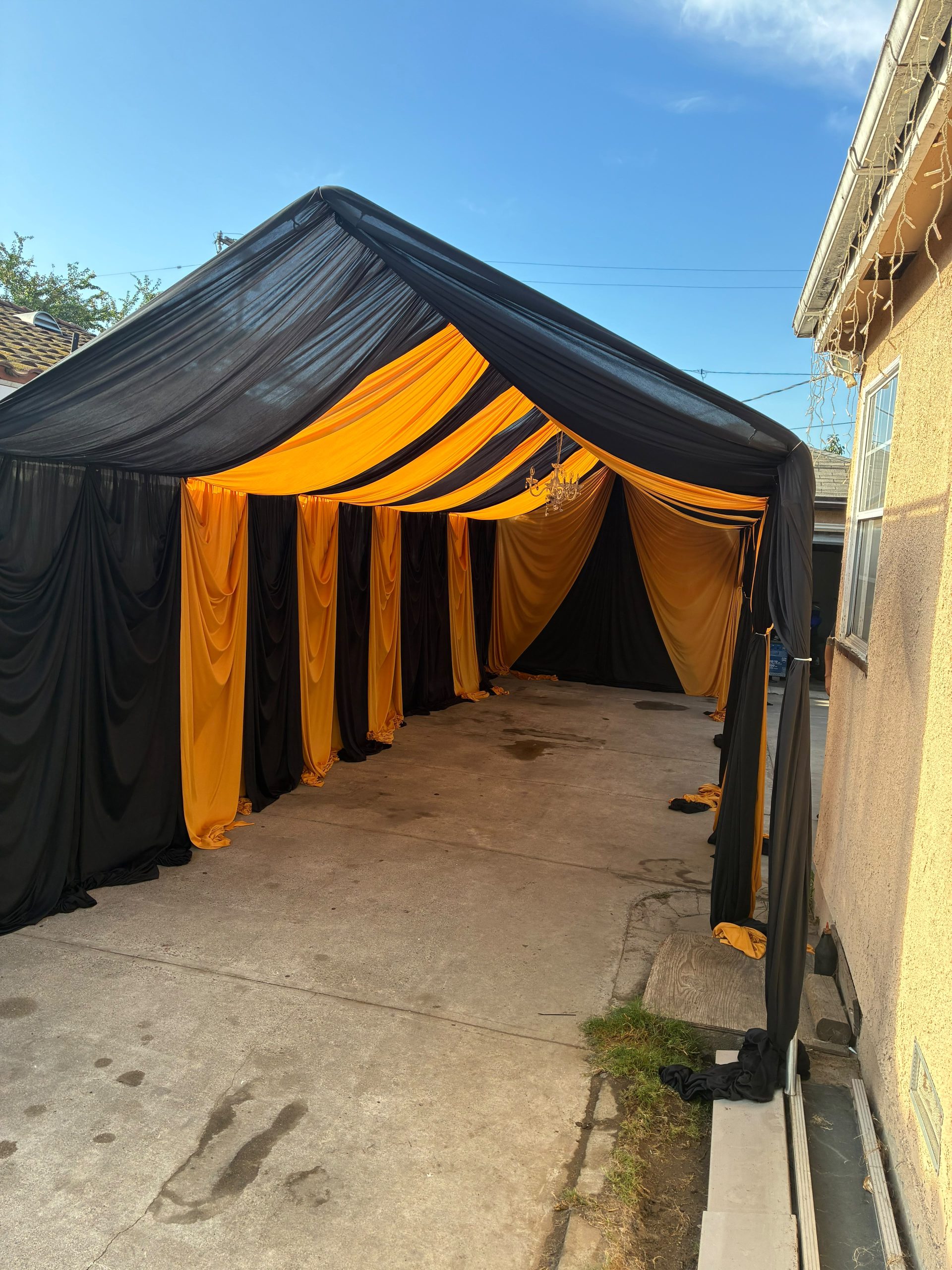 Real Loren's Party Rentals Black and gold draped tent prepared for a themed event. Style inspiration, not a size-specific product photograph.