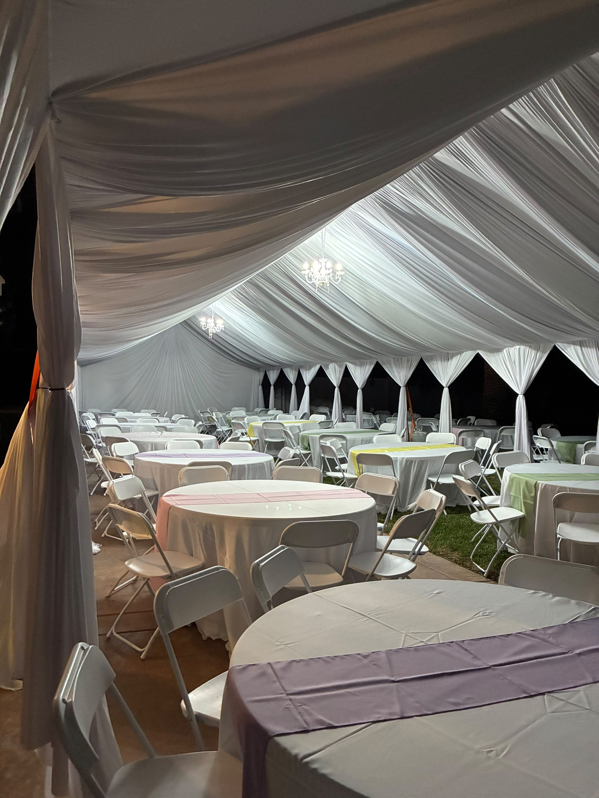 Real Loren's Party Rentals White flowing fabric ceiling and event seating at night. Style inspiration, not a size-specific product photograph.