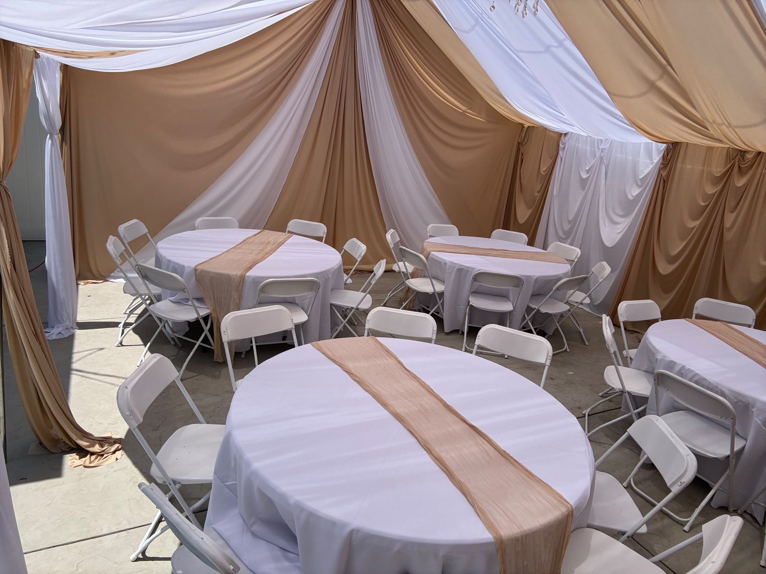 Real Loren's Party Rentals Champagne and ivory draping surrounding round reception tables. Style inspiration, not a size-specific product photograph.