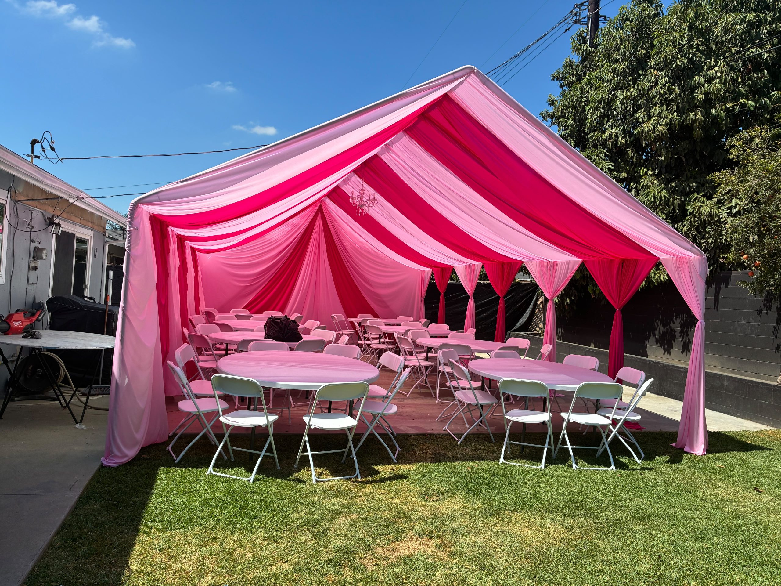 Real Loren's Party Rentals Pink draping under a peaked tent with event tables and seating. Style inspiration, not a size-specific product photograph.